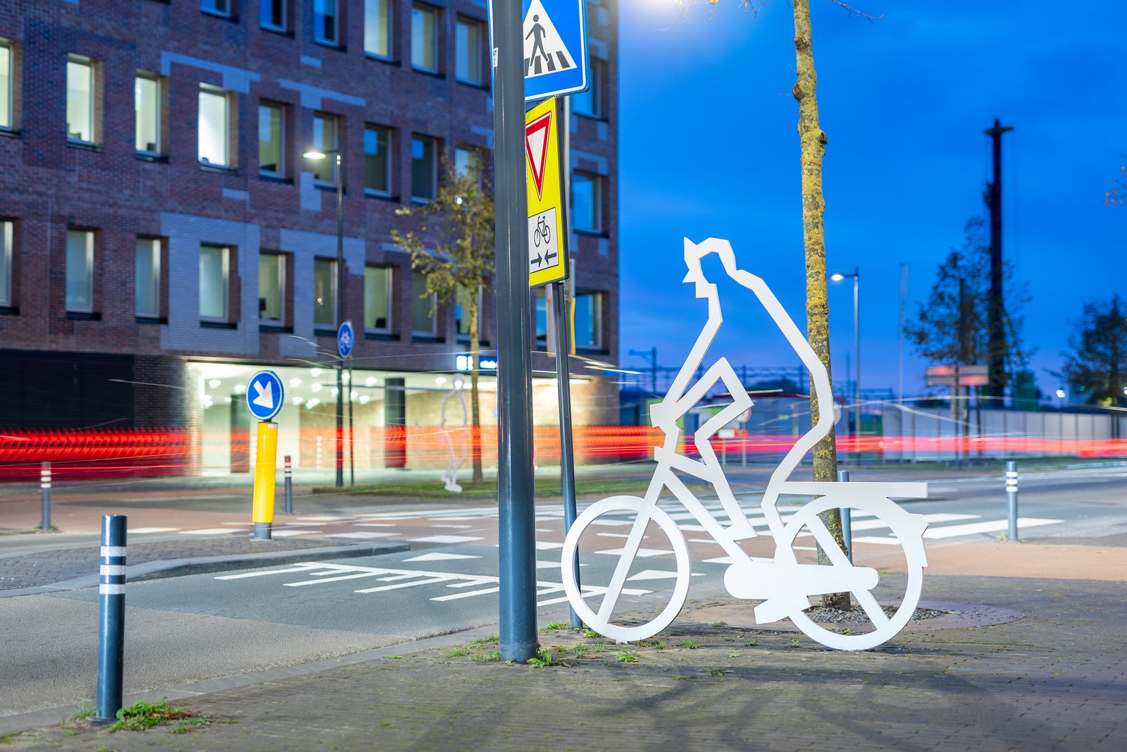 Attentiefiguur fietser bij nacht met stadsgezicht