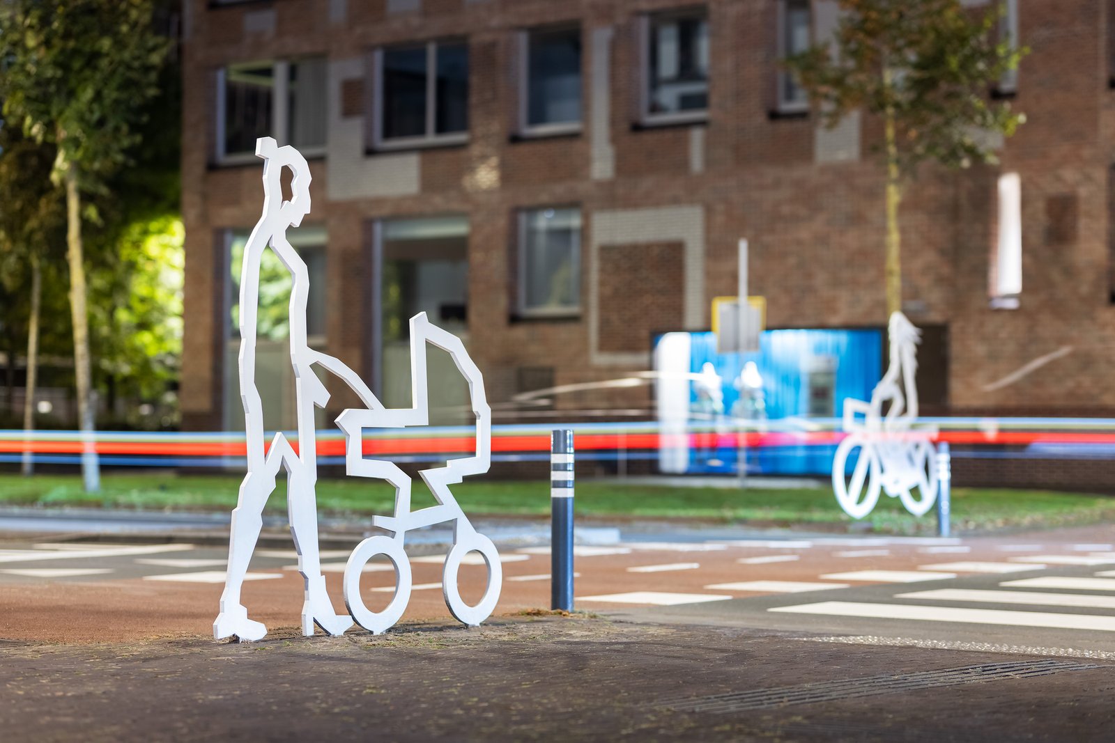 Attentiefiguur ouder met kinderwagen bij zebrapad