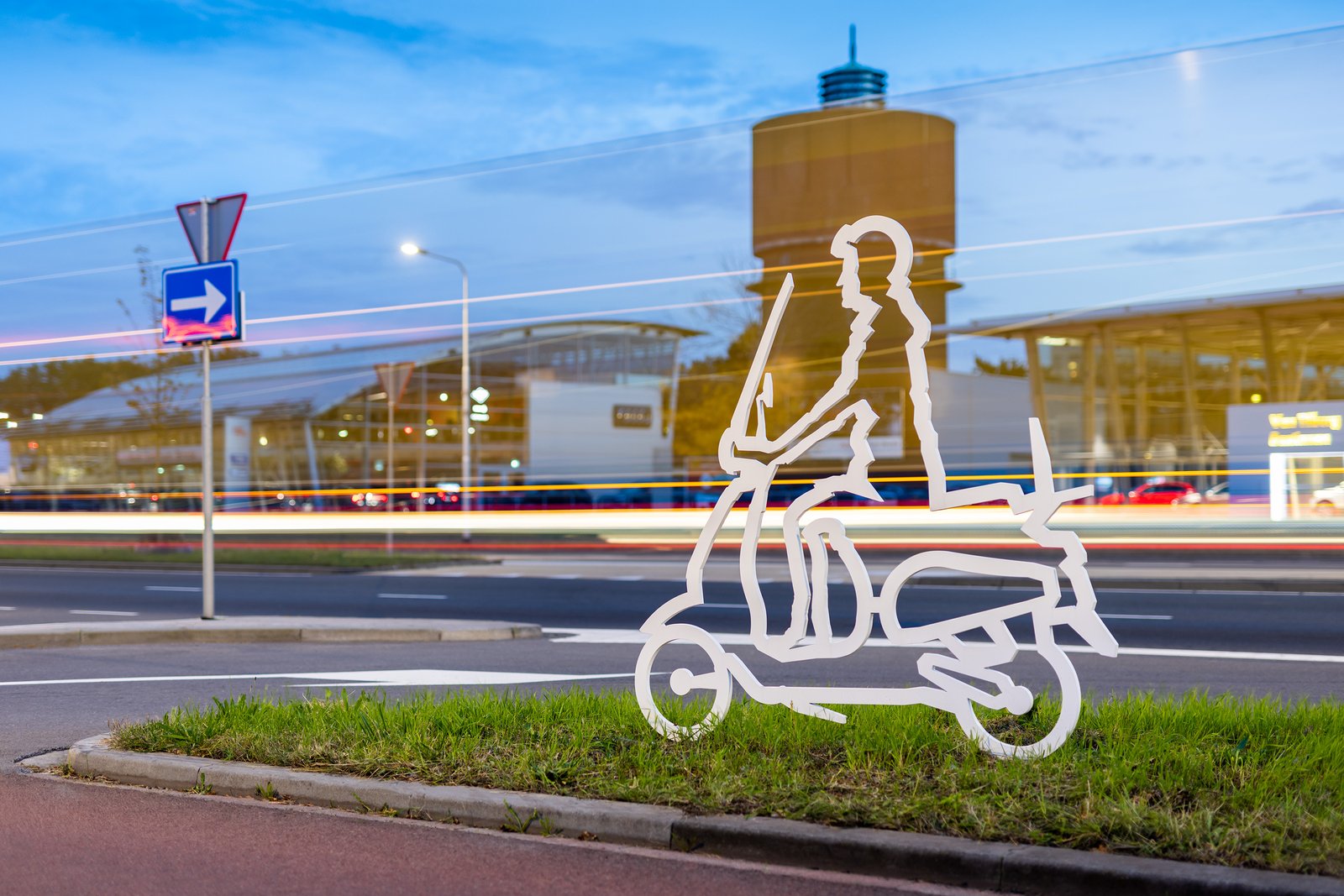 Attentiefiguur scooterrijder bij de watertoren in de schemering